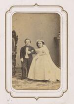 From the Fairy Wedding Album: Charles S. Stratton and M. Lavinia Warren in their wedding clothes standing arm in arm (version 2)