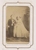 From the Fairy Wedding Album: Charles S. Stratton and M. Lavinia Warren in their wedding clothes standing arm in arm (version 1)