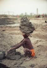 Bonded (slave) Child Laborer Loading Clay Onto His Head To Carry To The Drying Fields