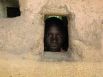boy in the Central African Republic peeks out of a window of a school