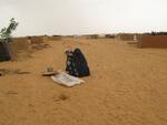 Darfuri woman pours grain at the Oure Cassoni refugee camp in Chad, near the border with Darfur