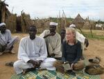 Actor and humanitarian Mia Farrow sits with Darfuri men at the Gouroukoum camp.