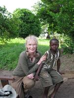 Actor and humanitarian Mia Farrow sits with a young Darfuri survivor of violence