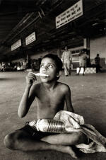 Boy Eats While Sitting On The Floor Of The Train Station
