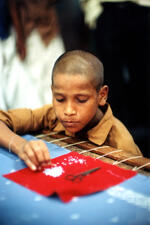 Boy Sews Beads Into Fabric