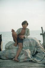 Boy Smokes a Cigarette on Jermal Off the Coast of Indonesia