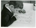 Young Boy Writing at Whitby School in Greenwich, Connecticut