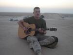 Al Asad, Iraq � LCPL O�Keefe; playing guitar on top of Hardened Aircraft Shelter (HAS); 7/2005