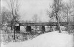 Postcard with an image of the bridge over the Quinebaug River in winter
