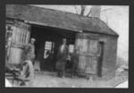Nelson H. Miner in front of his blacksmith shop